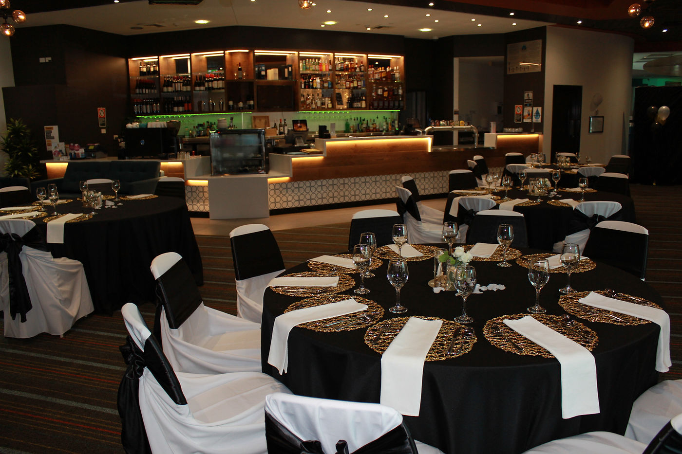 Wedding reception tables set up with black and gold styling at Yamba Bowling Club